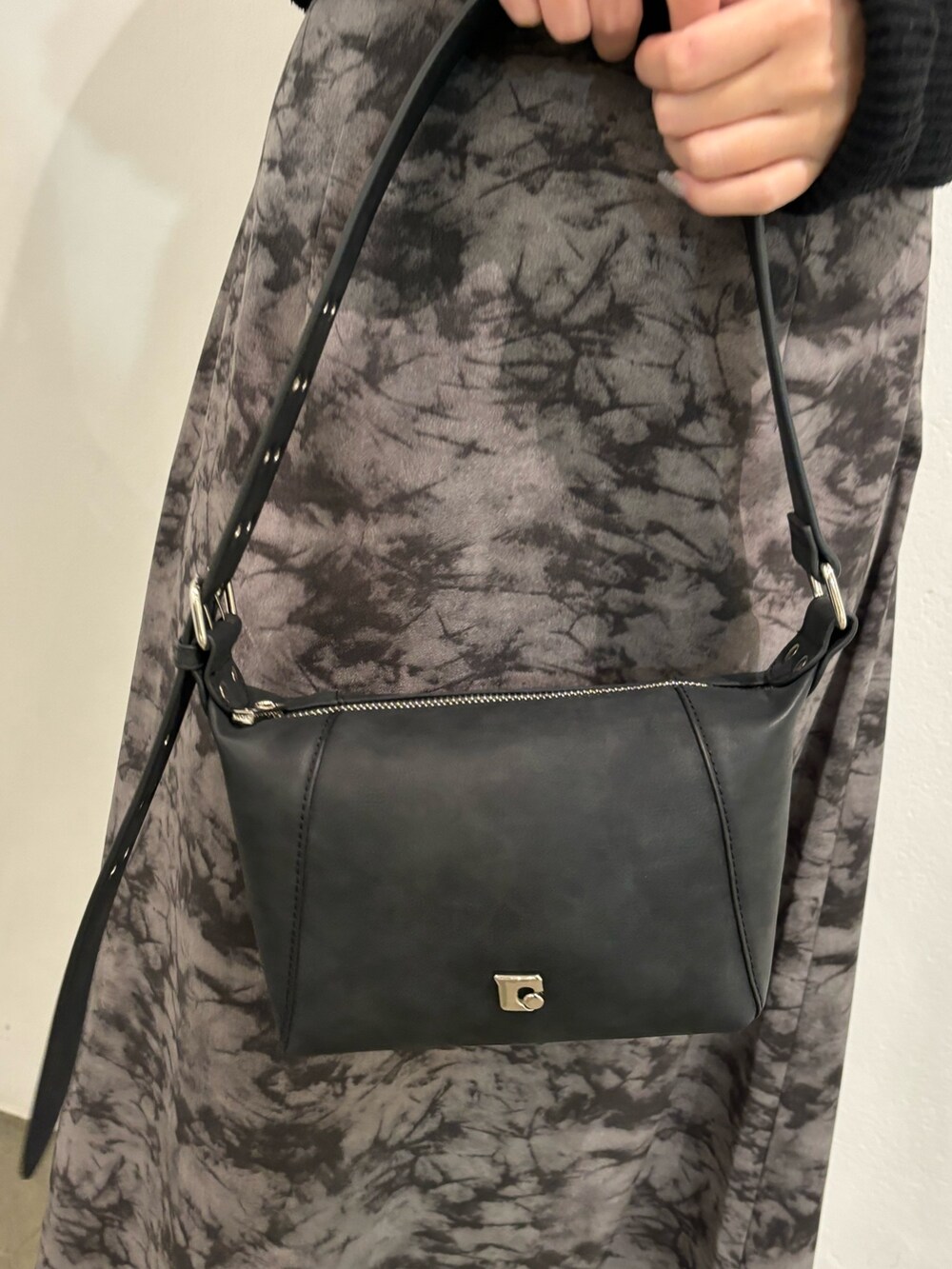 ブラック系のニット/セーター、ブラック系のショルダーバッグを着用したレディースの春コーディネートの6枚目の写真