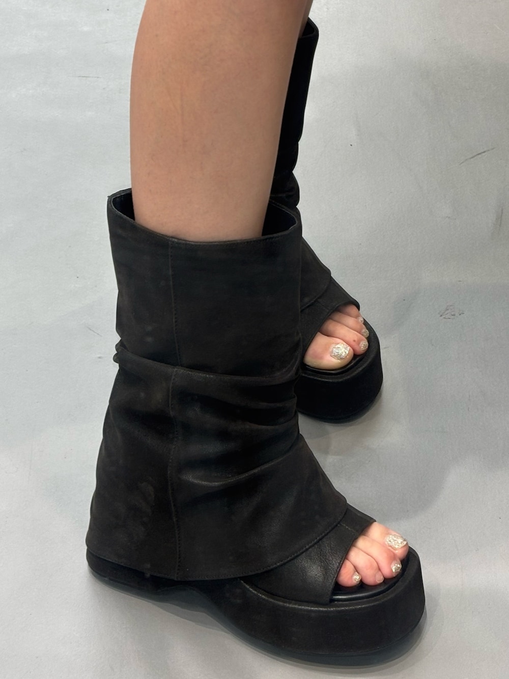 ブルー系のスカート、ブラック系のサンダル、ブラック系のその他トップスを着用したレディースの春コーディネートの5枚目の写真