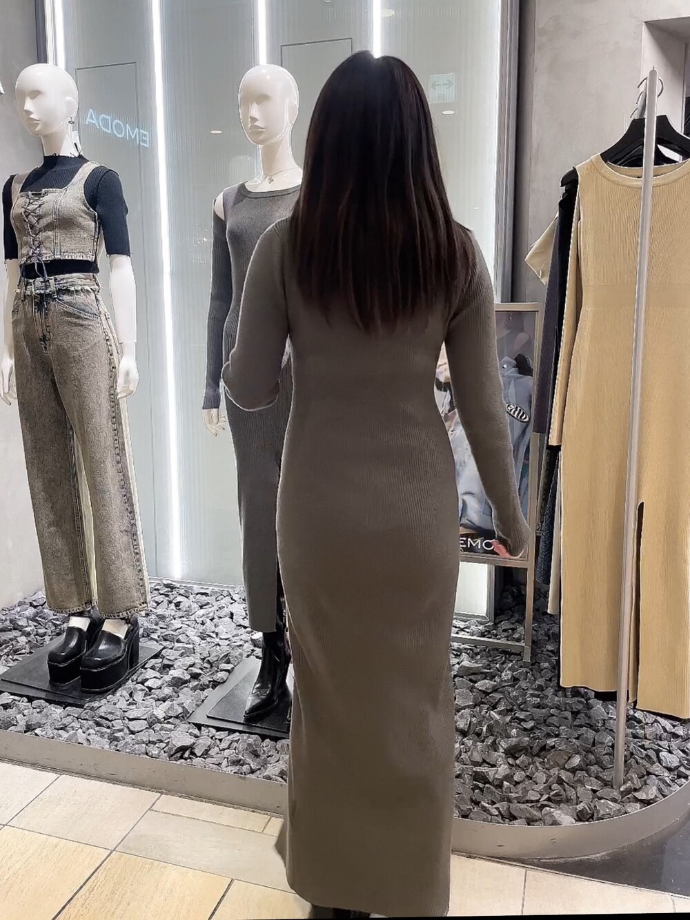 グレー系のワンピース、ブラック系のブーツを着用したレディースの春コーディネートの3枚目の写真