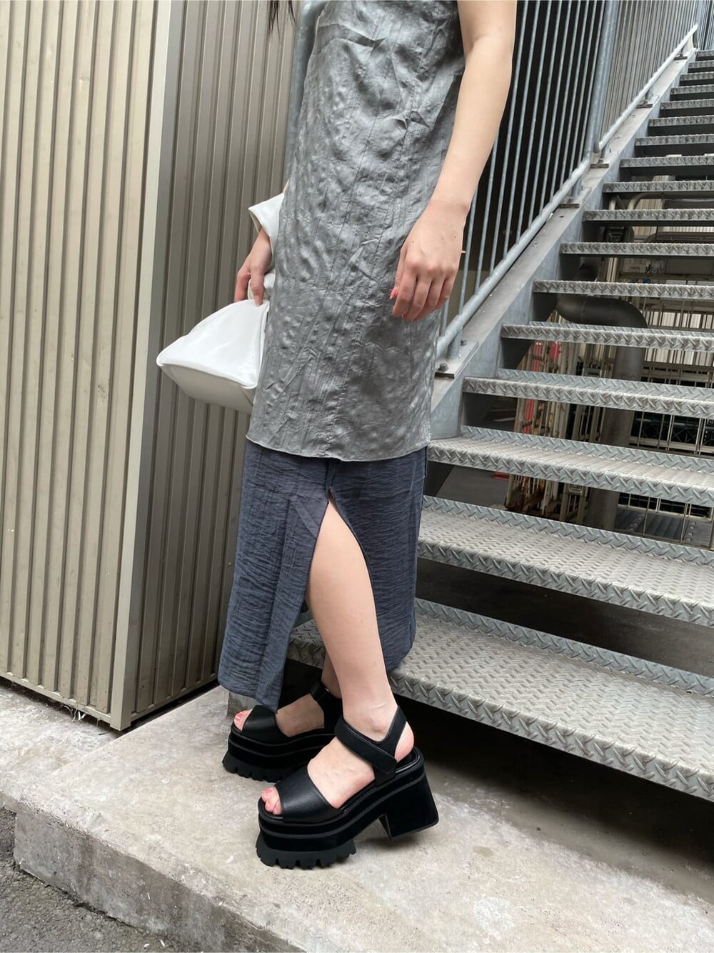 グレー系のワンピース、ホワイト系のハンドバッグを着用したレディースの夏コーディネートの4枚目の写真