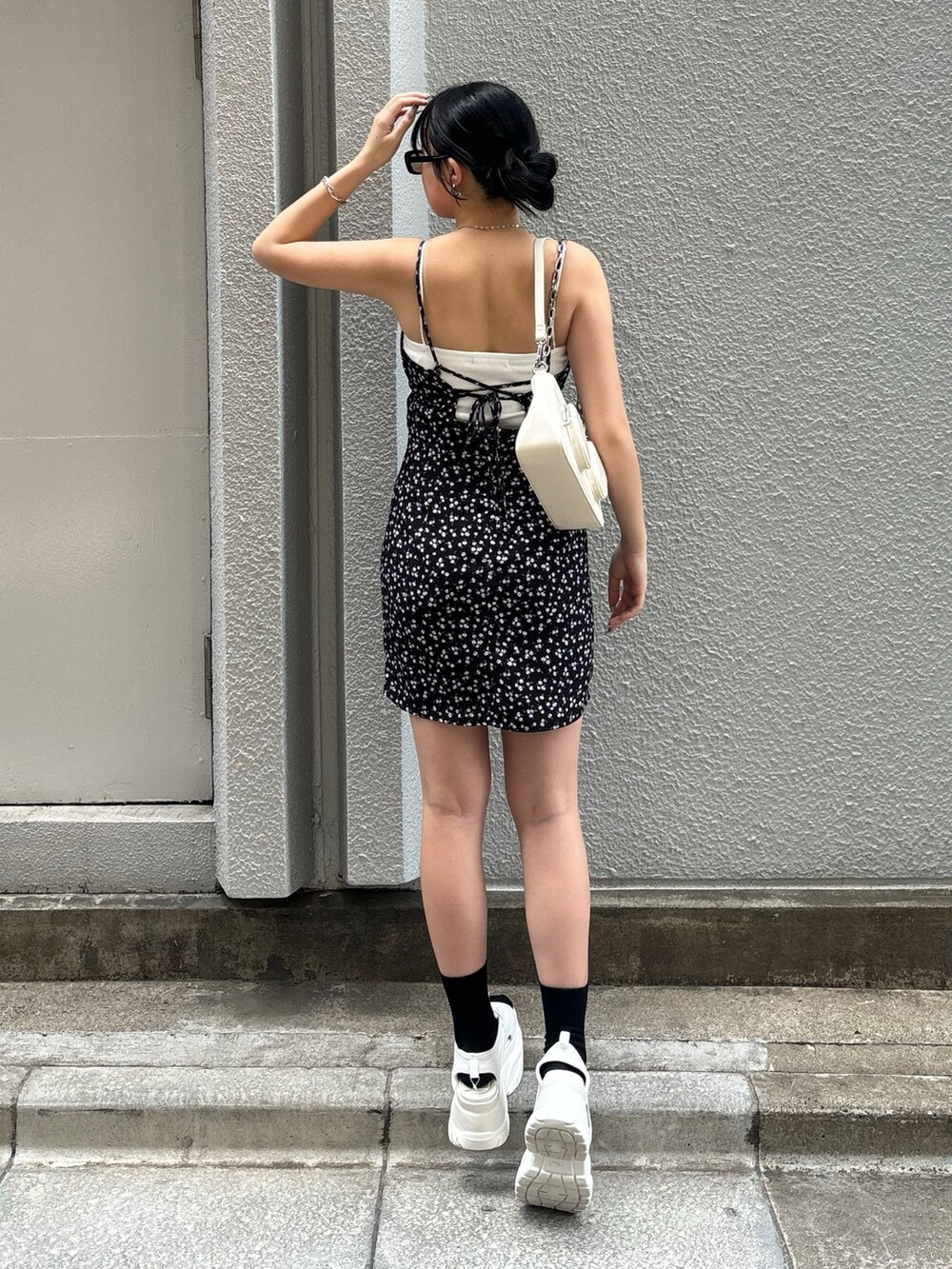 ホワイト系のサンダル、ホワイト系のショルダーバッグ、その他のワンピースを着用したレディースの夏コーディネートの2枚目の写真