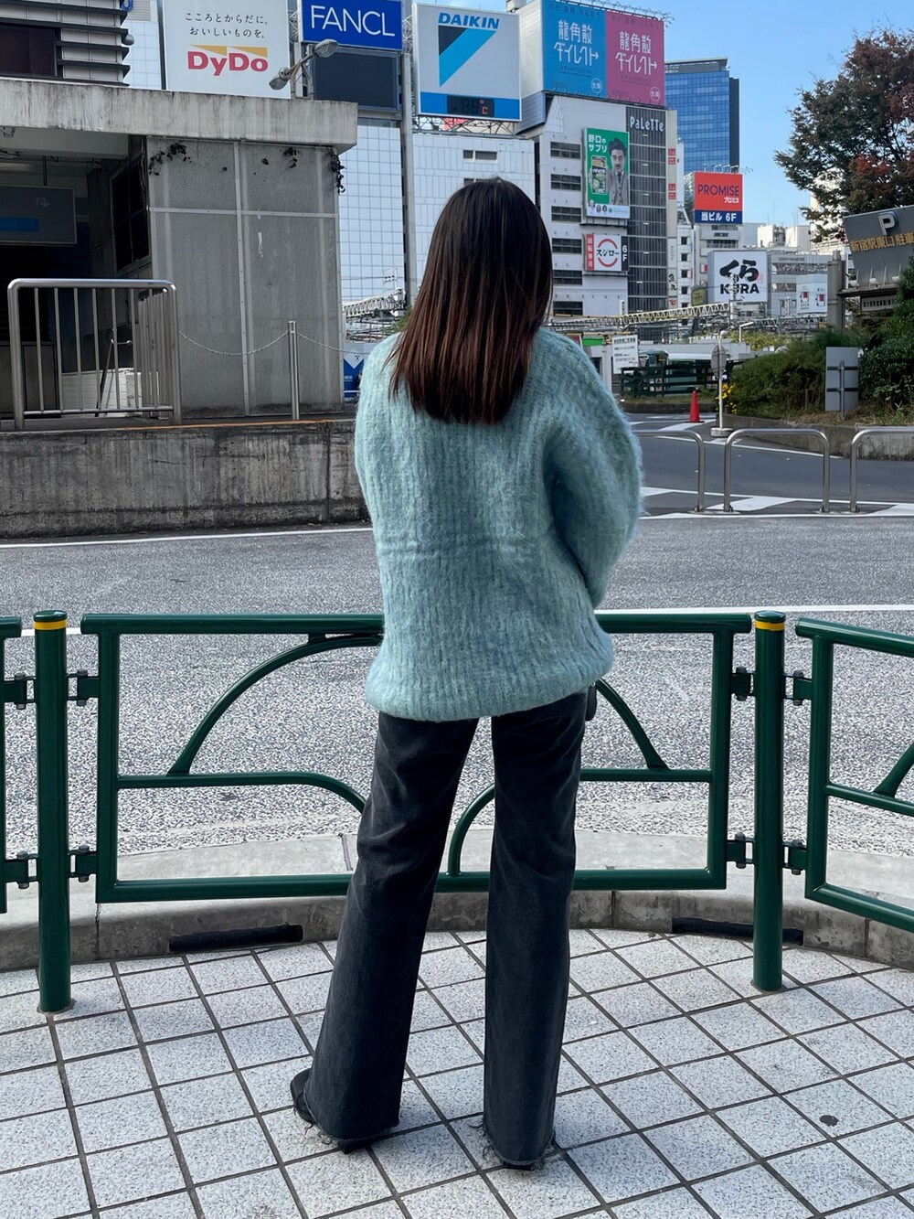 ブルー系のニット/セーター、ブラック系のデニムパンツ、ブラック系のブーツを着用したレディースの秋コーディネートの3枚目の写真