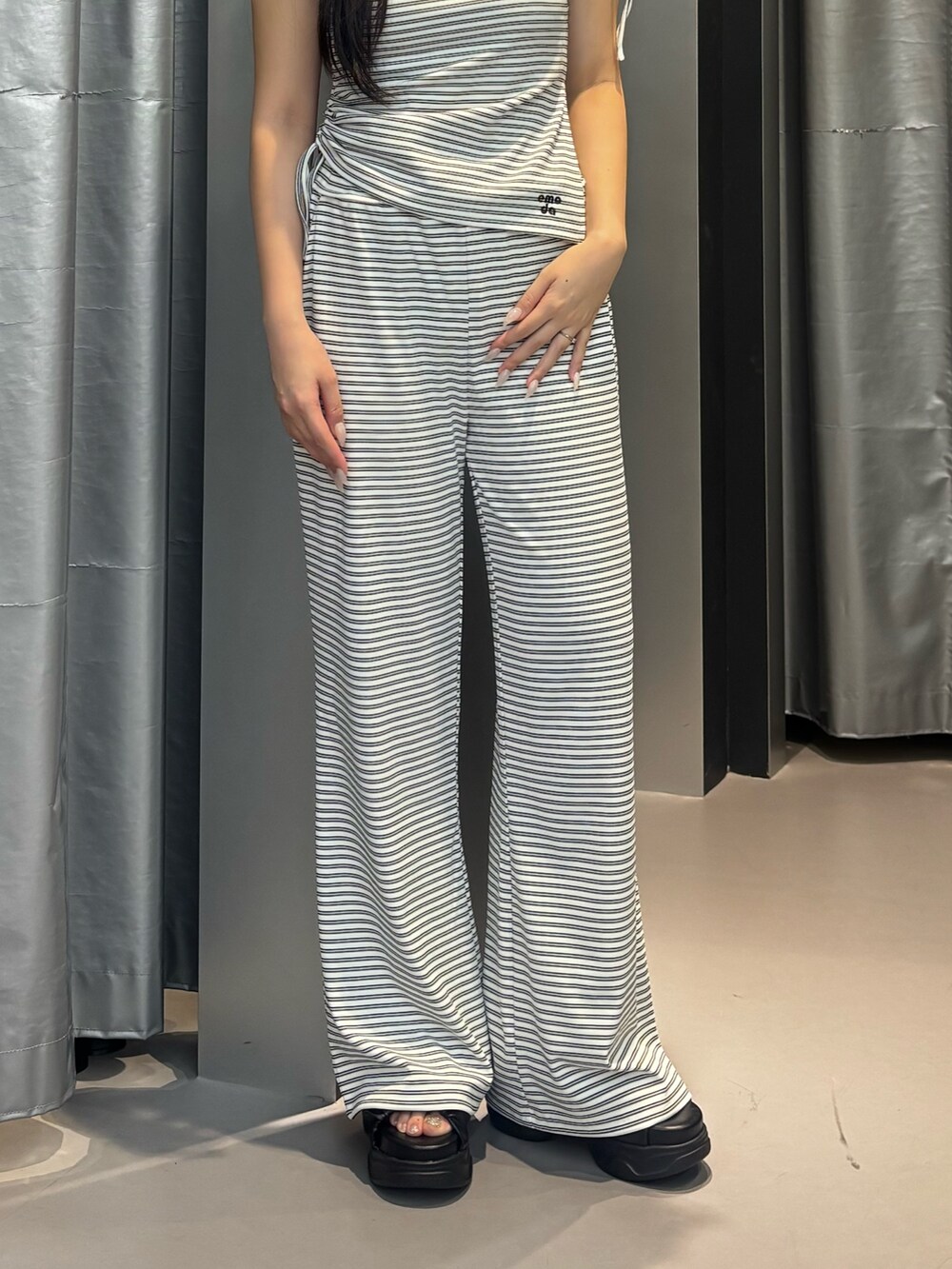ブラック系のサンダル、ホワイト系のその他パンツ、ホワイト系のTシャツ/カットソーを着用したレディースの夏コーディネートの7枚目の写真