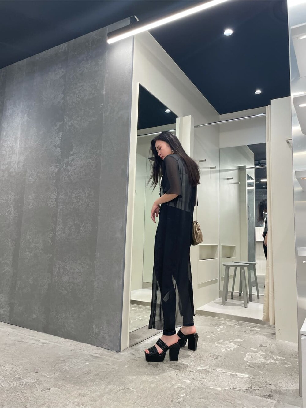 ブラック系のシャツ/ブラウス、ベージュ系のハンドバッグ、ホワイト系のニット/セーターを着用したレディースの夏コーディネートの3枚目の写真