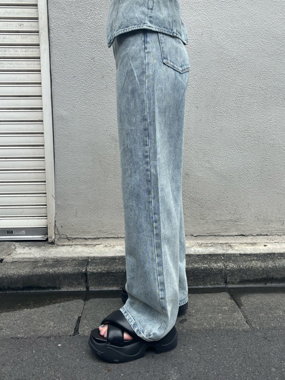 ブラック系のサンダル、ブルー系のデニムパンツ、ブルー系のキャミソールを着用したレディースの夏コーディネートの6枚目の写真