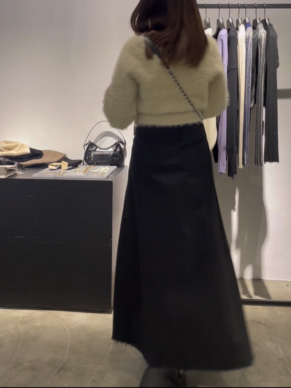 ホワイト系のニット/セーター、ブラック系のスカート、ブラック系のブーツを着用したレディースの冬コーディネートの3枚目の写真