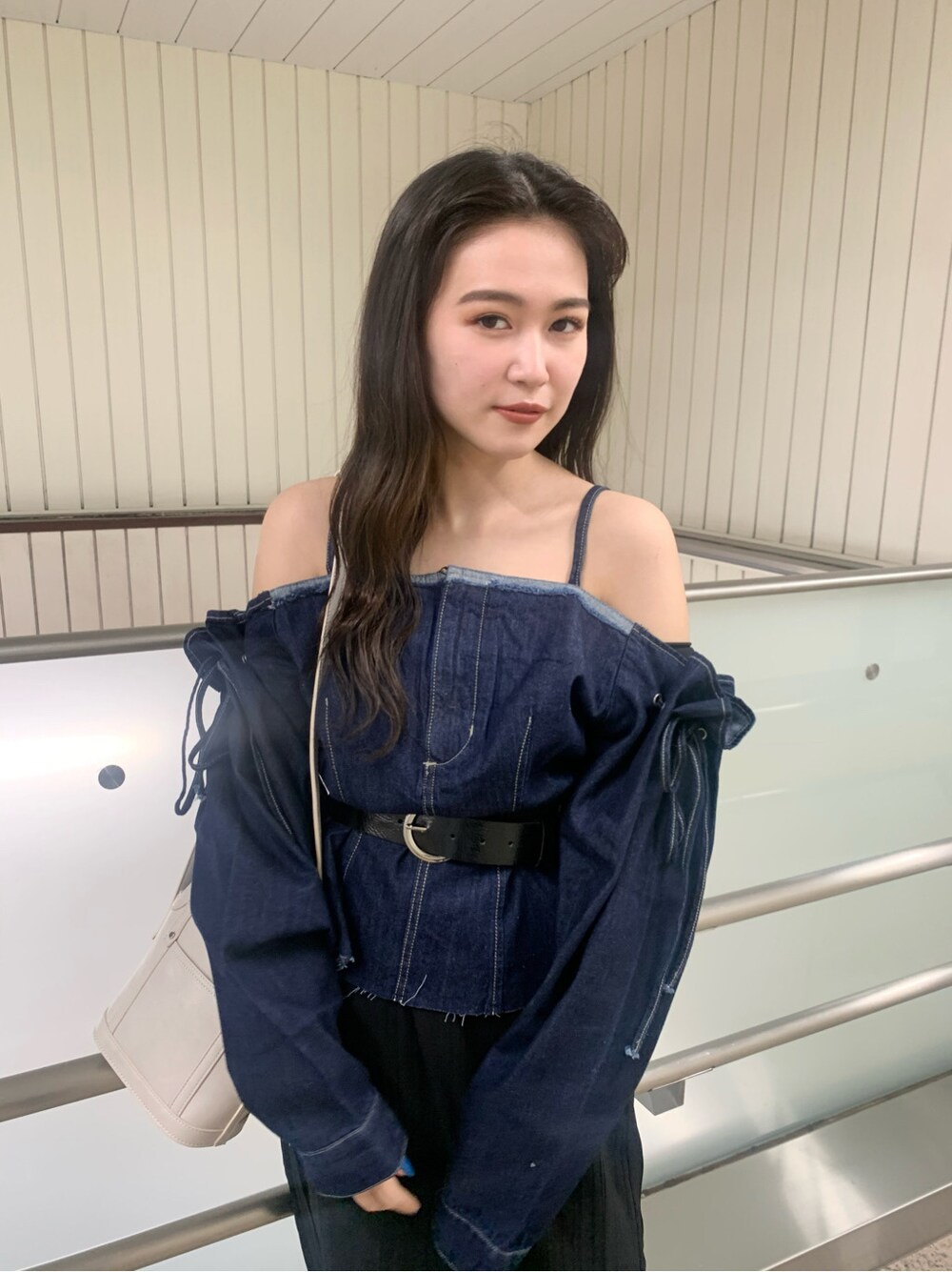 ブラック系のスカート、ホワイト系のショルダーバッグ、ホワイト系のサンダルを着用したレディースの春コーディネートの4枚目の写真