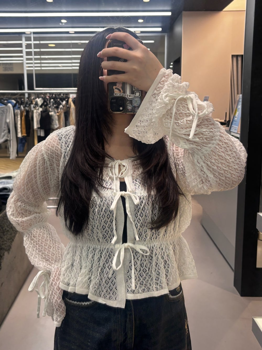 ブラック系のスニーカー、ブルー系のデニムパンツ、ホワイト系のニット/セーターを着用したレディースの春コーディネートの3枚目の写真