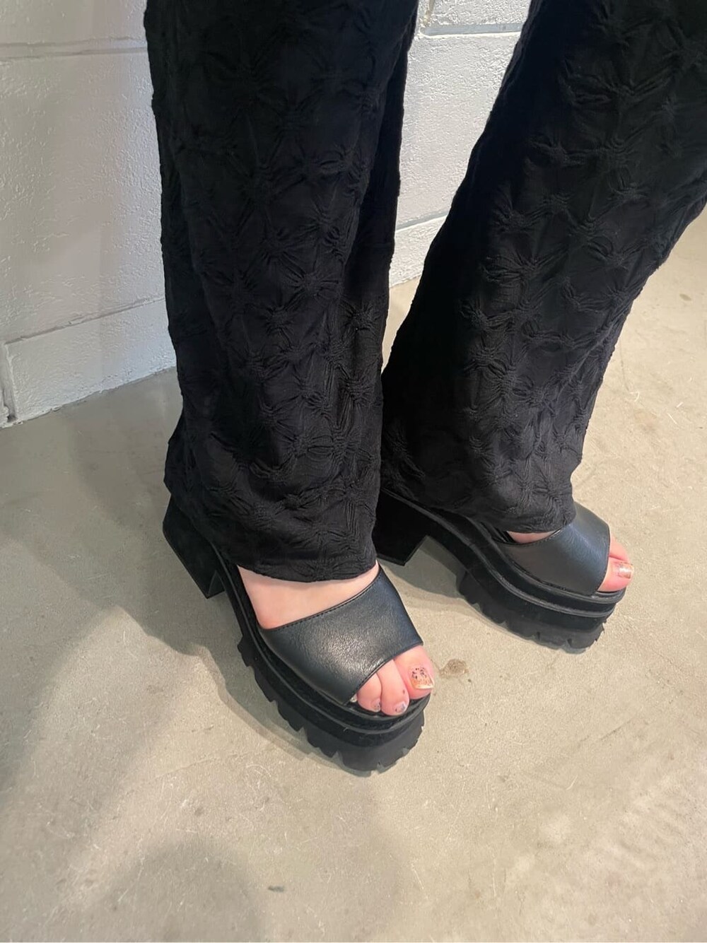 ブラック系のその他パンツ、ブラック系のサンダル、ホワイト系のTシャツ/カットソーを着用したレディースの夏コーディネートの6枚目の写真