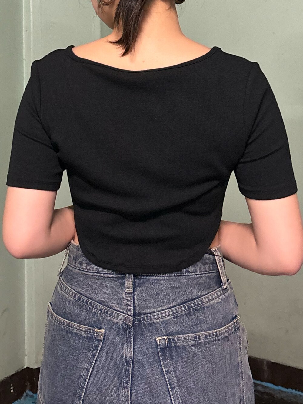 ブルー系のデニムパンツ、ブラック系のTシャツ/カットソー、ブラック系のサンダルを着用したレディースの夏コーディネートの6枚目の写真