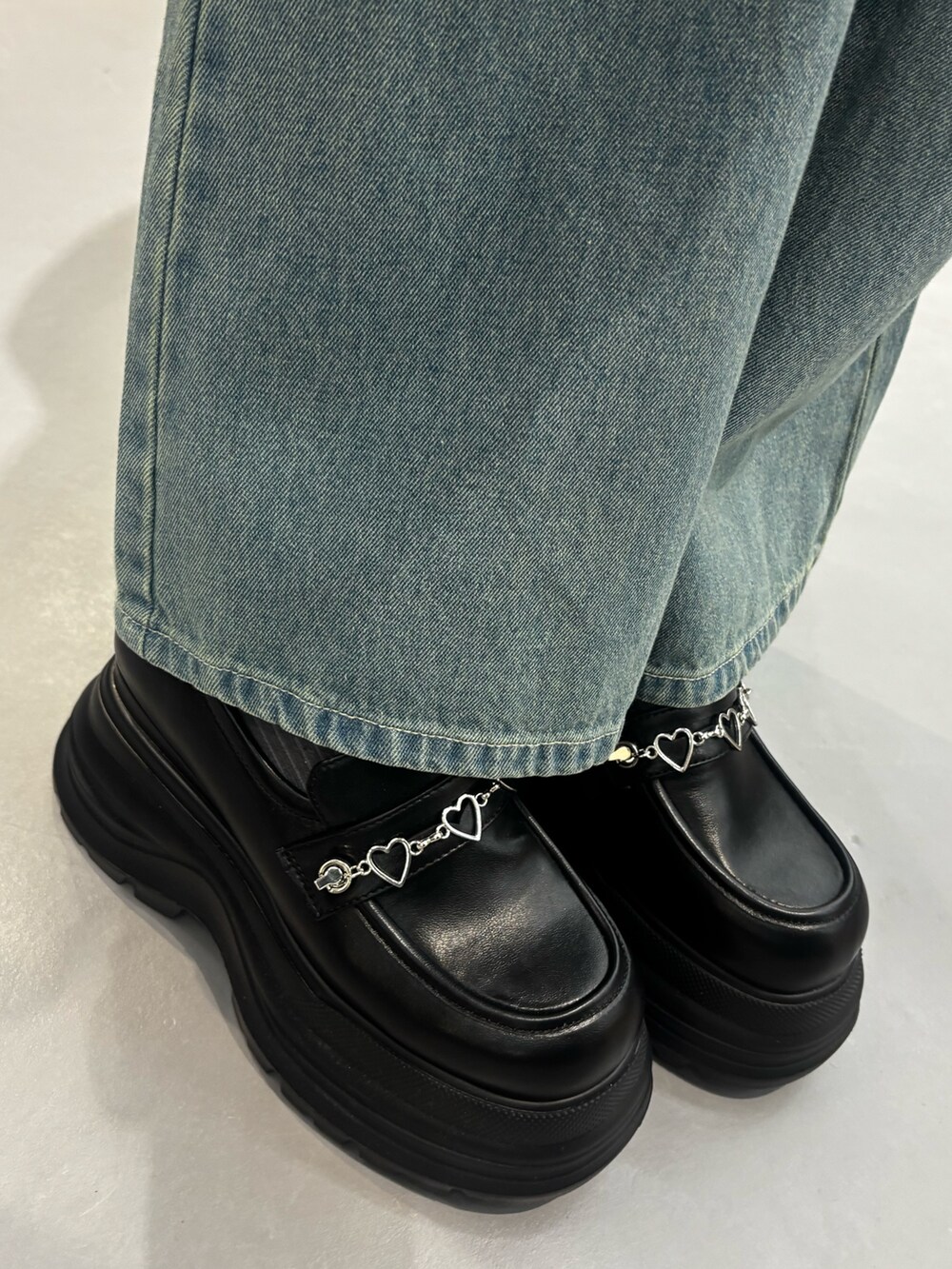 ブラック系のローファー、ベージュ系のデニムパンツを着用したレディースの冬コーディネートの5枚目の写真