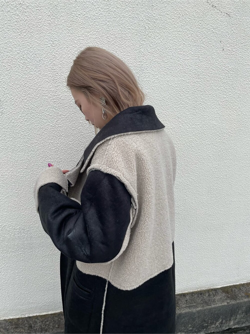 ブラック系のTシャツ/カットソー、ブラック系のデニムパンツ、ブラック系のムートンコートを着用したレディースの秋コーディネートの4枚目の写真