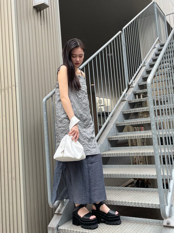 グレー系のワンピース、ホワイト系のハンドバッグを着用したレディースの夏コーディネートの2枚目の写真