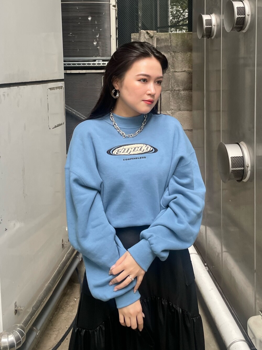 ブラック系のブーツ、ブラック系のスカート、ブルー系のスウェットを着用したレディースの秋コーディネートの6枚目の写真