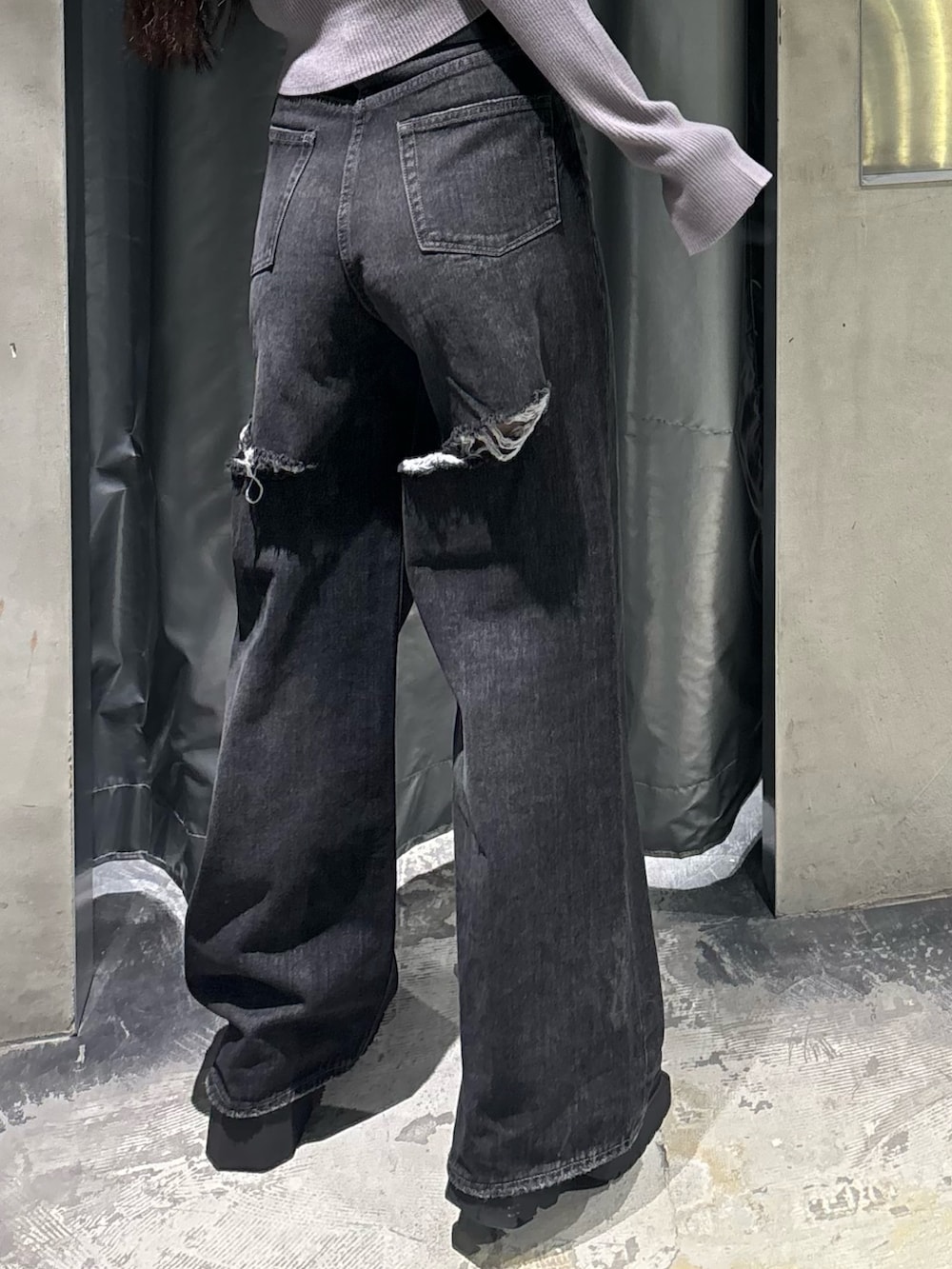 ブルー系のデニムパンツ、グレー系のニット/セーター、ブラック系のブーツを着用したレディースの秋コーディネートの5枚目の写真