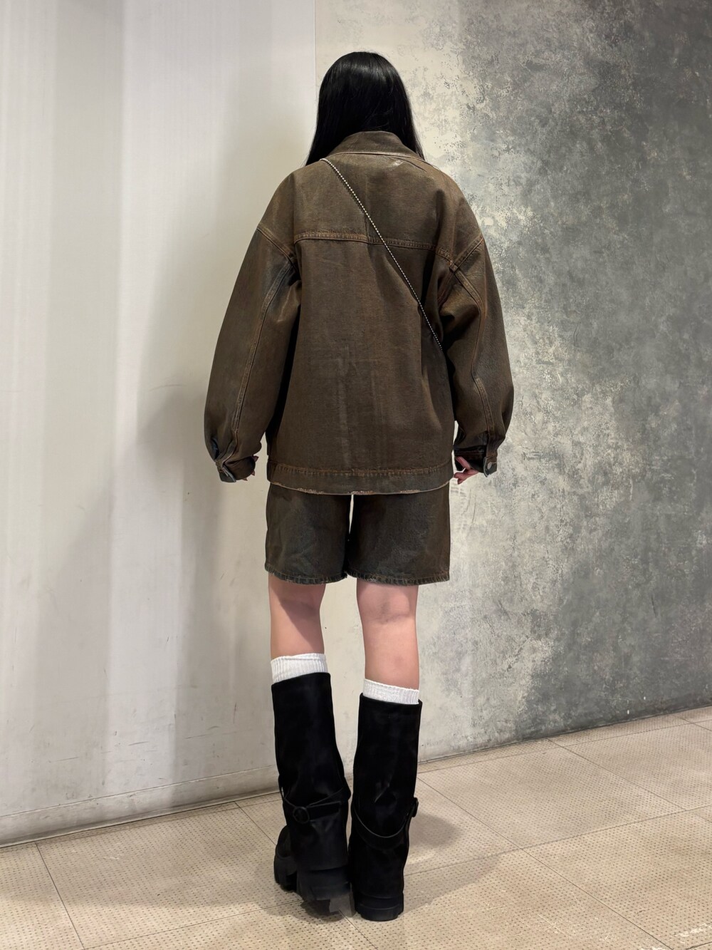 ブラック系のデニムパンツ、ブラック系のブーツ、ブラック系のブルゾンを着用したレディースの冬コーディネートの3枚目の写真