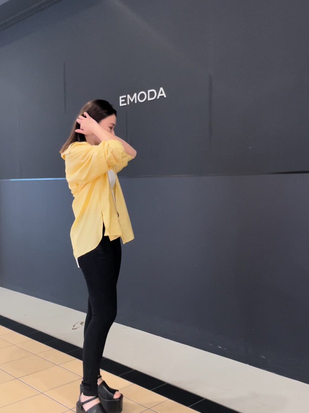 ブラック系のサンダル、ブラック系のデニムパンツ、ホワイト系のタンクトップを着用したレディースの夏コーディネートの4枚目の写真