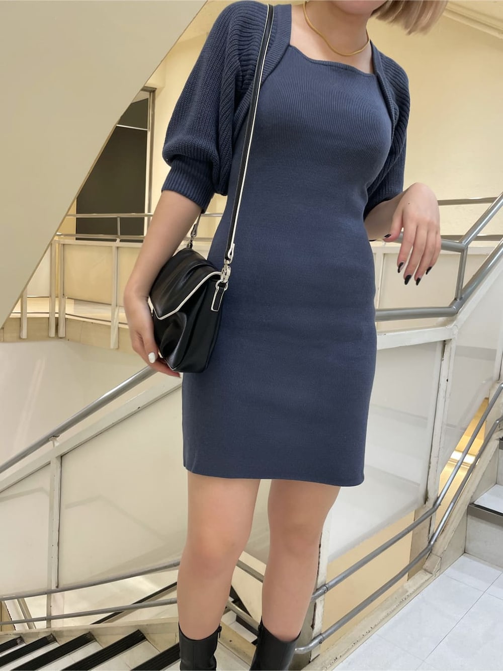 ブラック系のブーツ、ブルー系のワンピース、ブラック系のショルダーバッグを着用したレディースの秋コーディネートの4枚目の写真