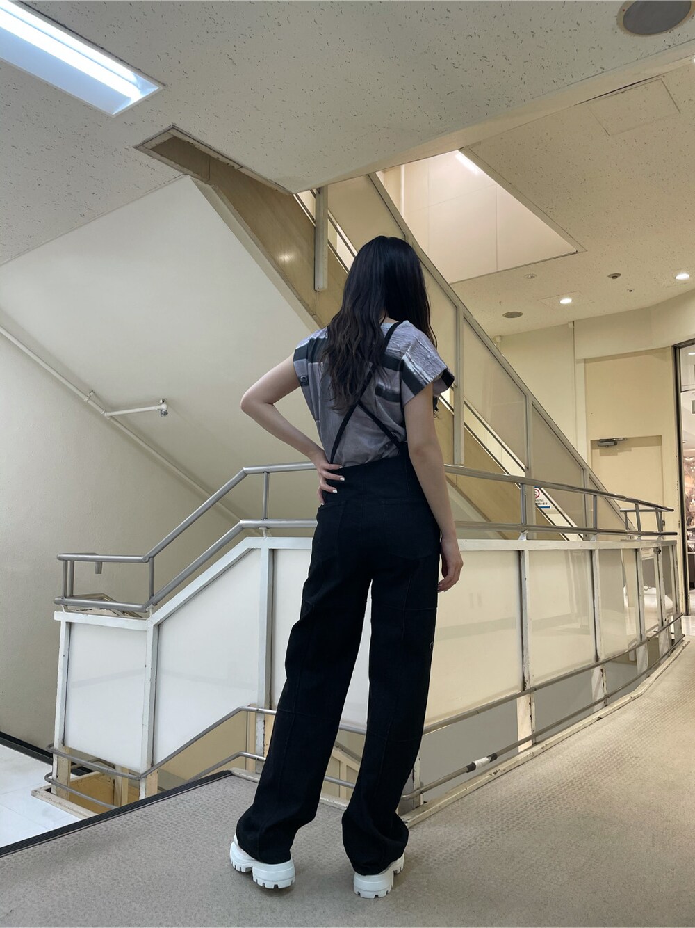 ホワイト系のサンダル、ブラック系のサロペット/オーバーオール、グレー系のTシャツ/カットソーを着用したレディースの春コーディネートの3枚目の写真