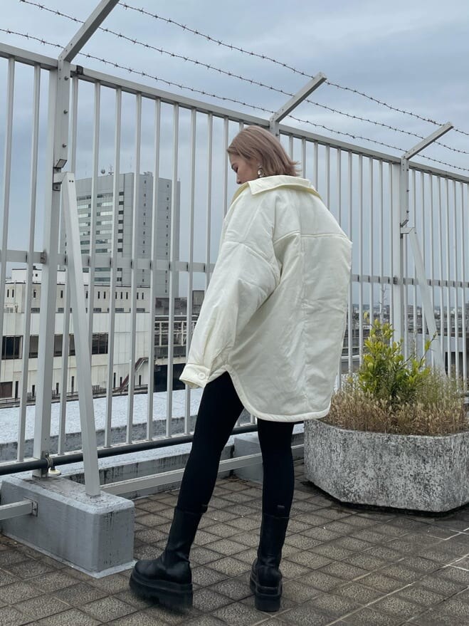 ブラック系のデニムパンツ、ホワイト系のブルゾン、その他のニット/セーターを着用したレディースの秋コーディネートの3枚目の写真