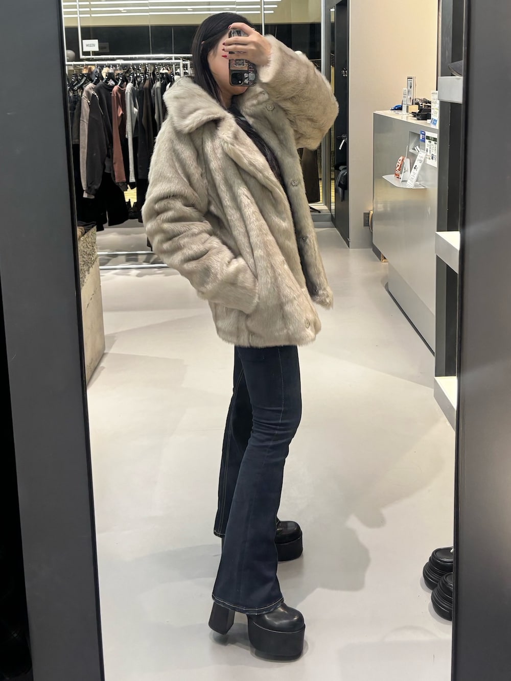 ブラック系のブーツ、ブルー系のデニムパンツ、ブラック系のニット/セーターを着用したレディースの秋コーディネートの2枚目の写真