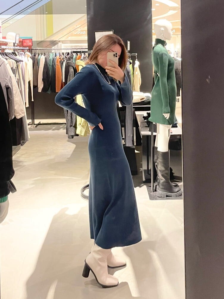 ブルー系のワンピース、ホワイト系のブーツ、シルバー系のネックレスを着用したレディースの冬コーディネートの2枚目の写真