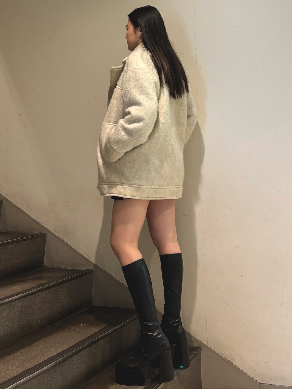 その他のブーツ、ホワイト系のピーコート、グレー系のニット/セーターを着用したレディースの秋コーディネートの2枚目の写真