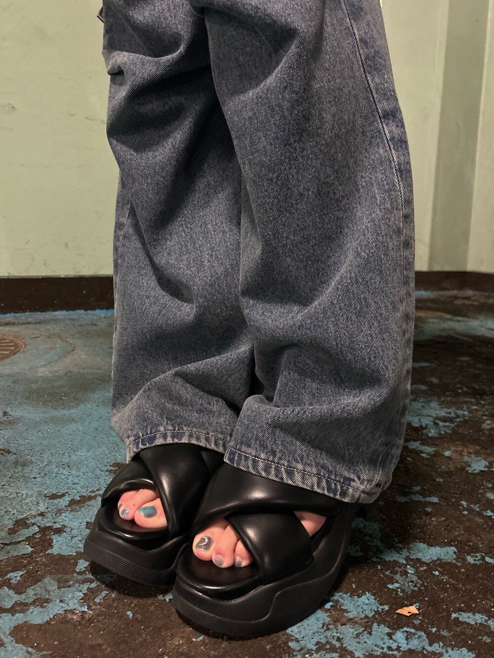 ブルー系のデニムパンツ、ブラック系のTシャツ/カットソー、ブラック系のサンダルを着用したレディースの夏コーディネートの10枚目の写真