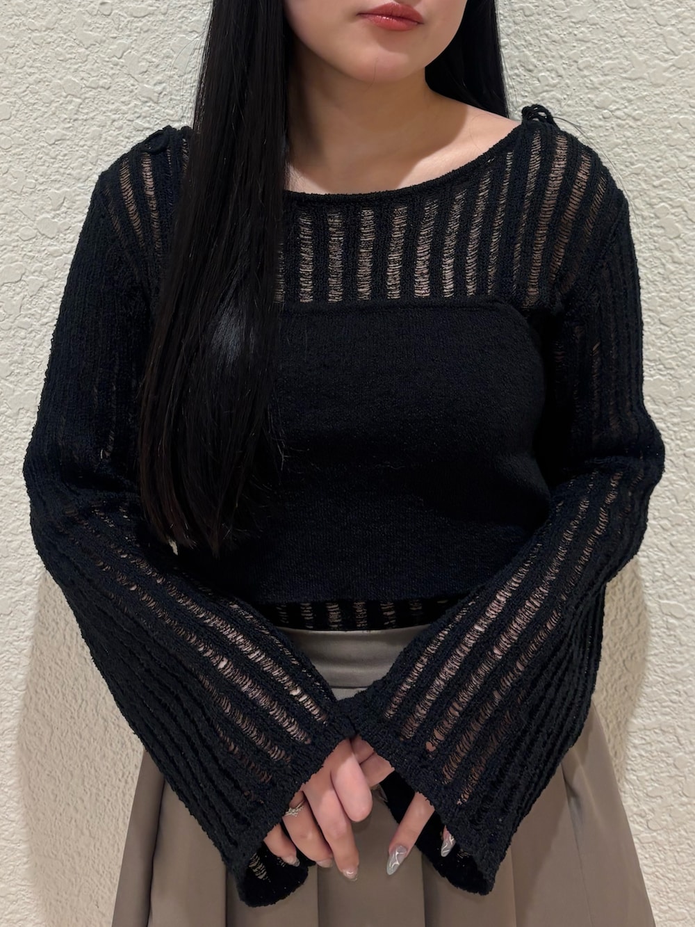 ブラック系のサンダル、ベージュ系のスカート、ブラック系のニット/セーターを着用したレディースの春コーディネートの4枚目の写真