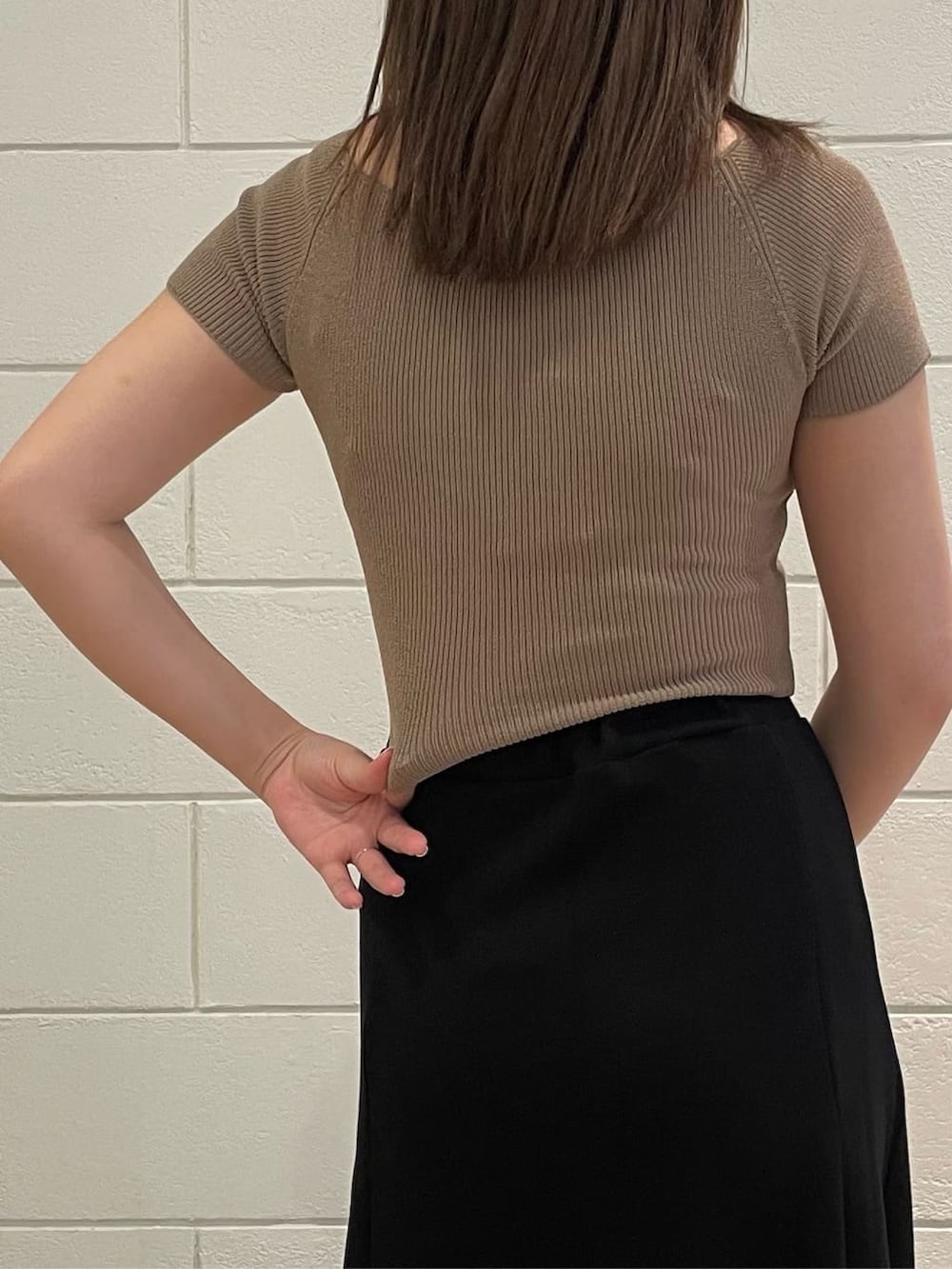 ベージュ系のニット/セーター、ブラック系のスカート、ブラック系のサンダルを着用したレディースの夏コーディネートの5枚目の写真