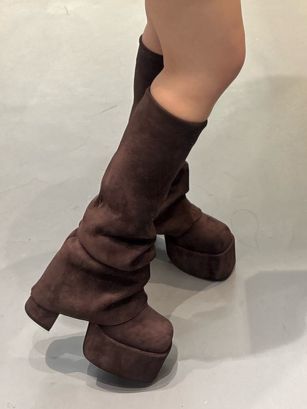 ホワイト系のブーツ、グレー系のスカートを着用したレディースの秋コーディネートの6枚目の写真