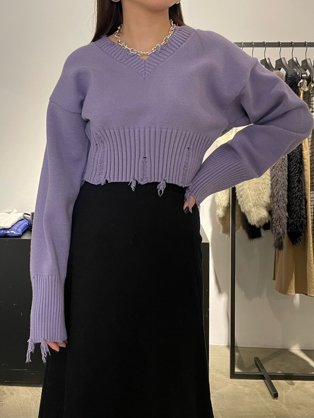 ブラック系のスカート、ブラック系のブーツ、パープル系のニット/セーターを着用したレディースの冬コーディネートの3枚目の写真