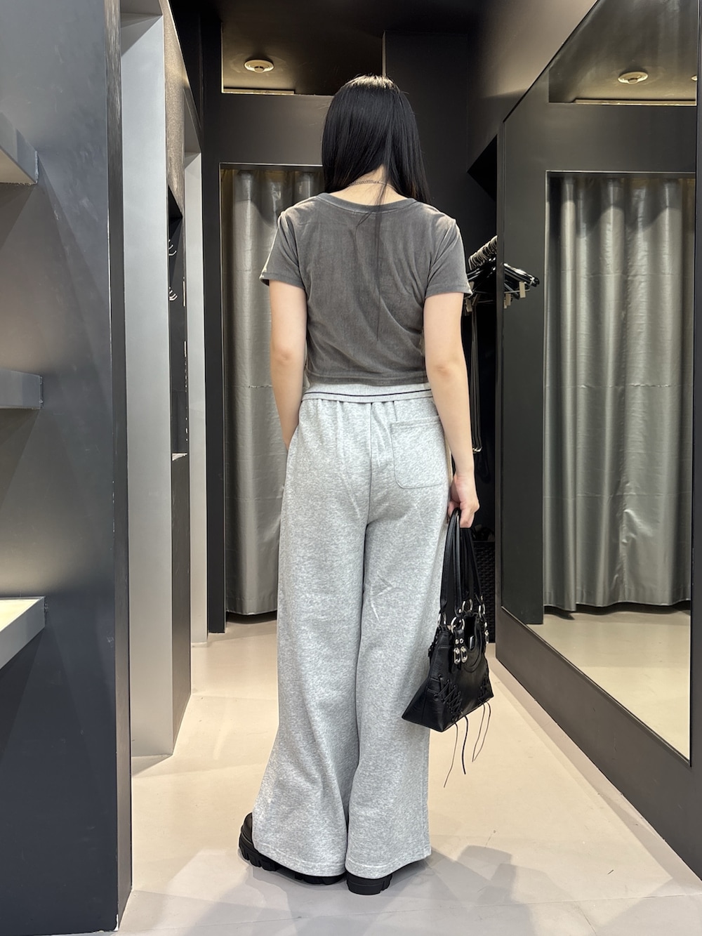 ブラック系のブーツ、ブラック系のショルダーバッグ、グレー系のTシャツ/カットソーを着用したレディースの夏コーディネートの3枚目の写真