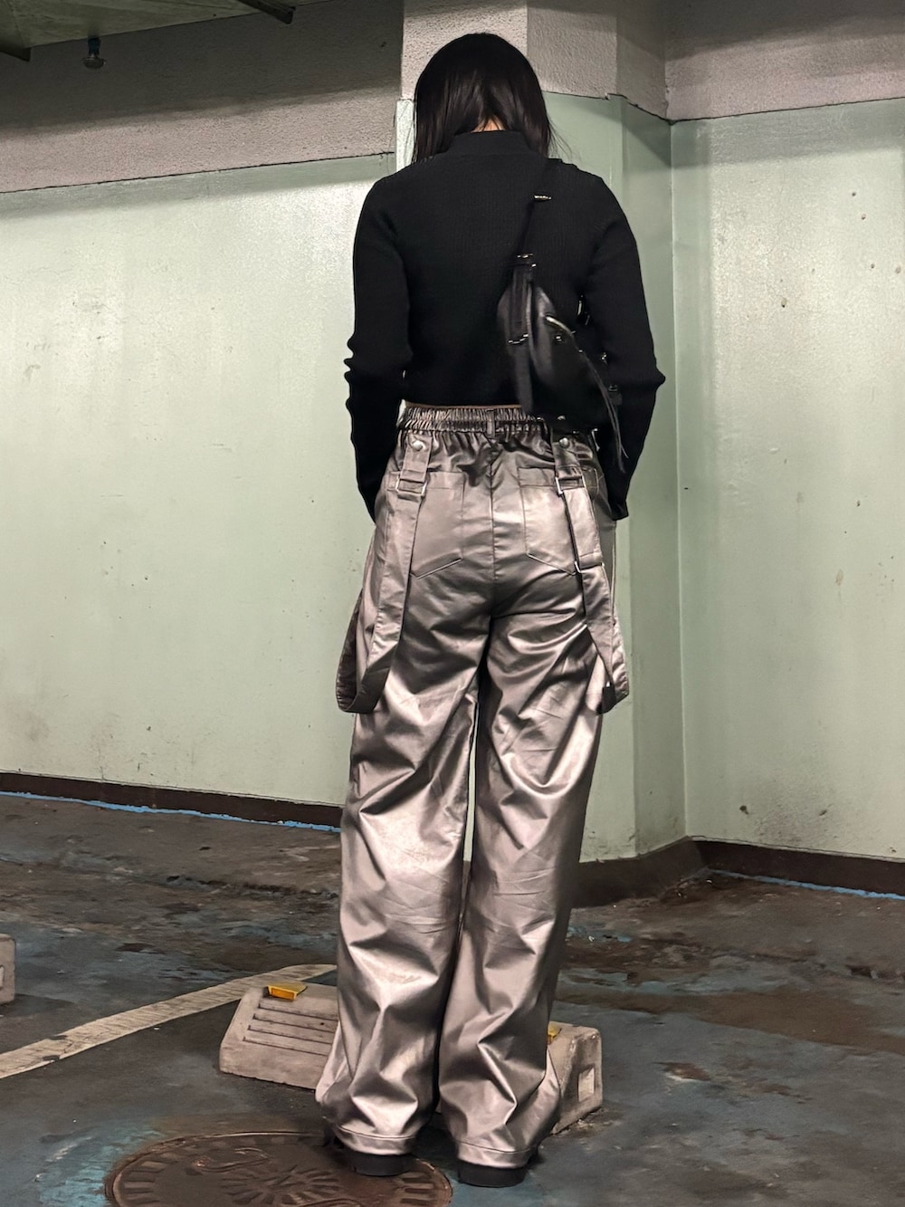 シルバー系のその他パンツ、ブラック系のニット/セーター、ブラック系のスニーカーを着用したレディースの冬コーディネートの3枚目の写真