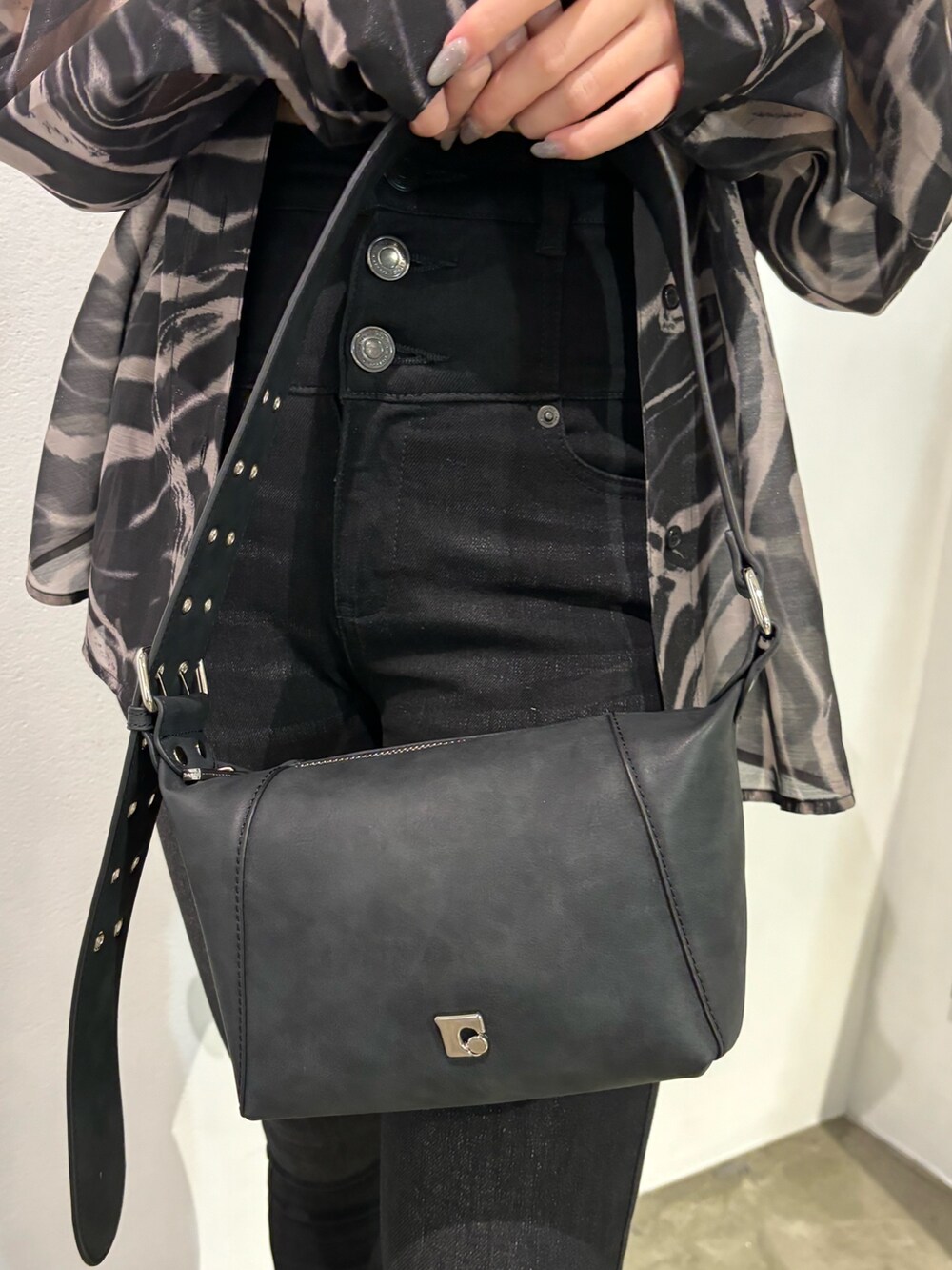 ブラック系のデニムパンツ、ベージュ系のシャツ/ブラウス、ブラック系のショルダーバッグを着用したレディースの春コーディネートの7枚目の写真