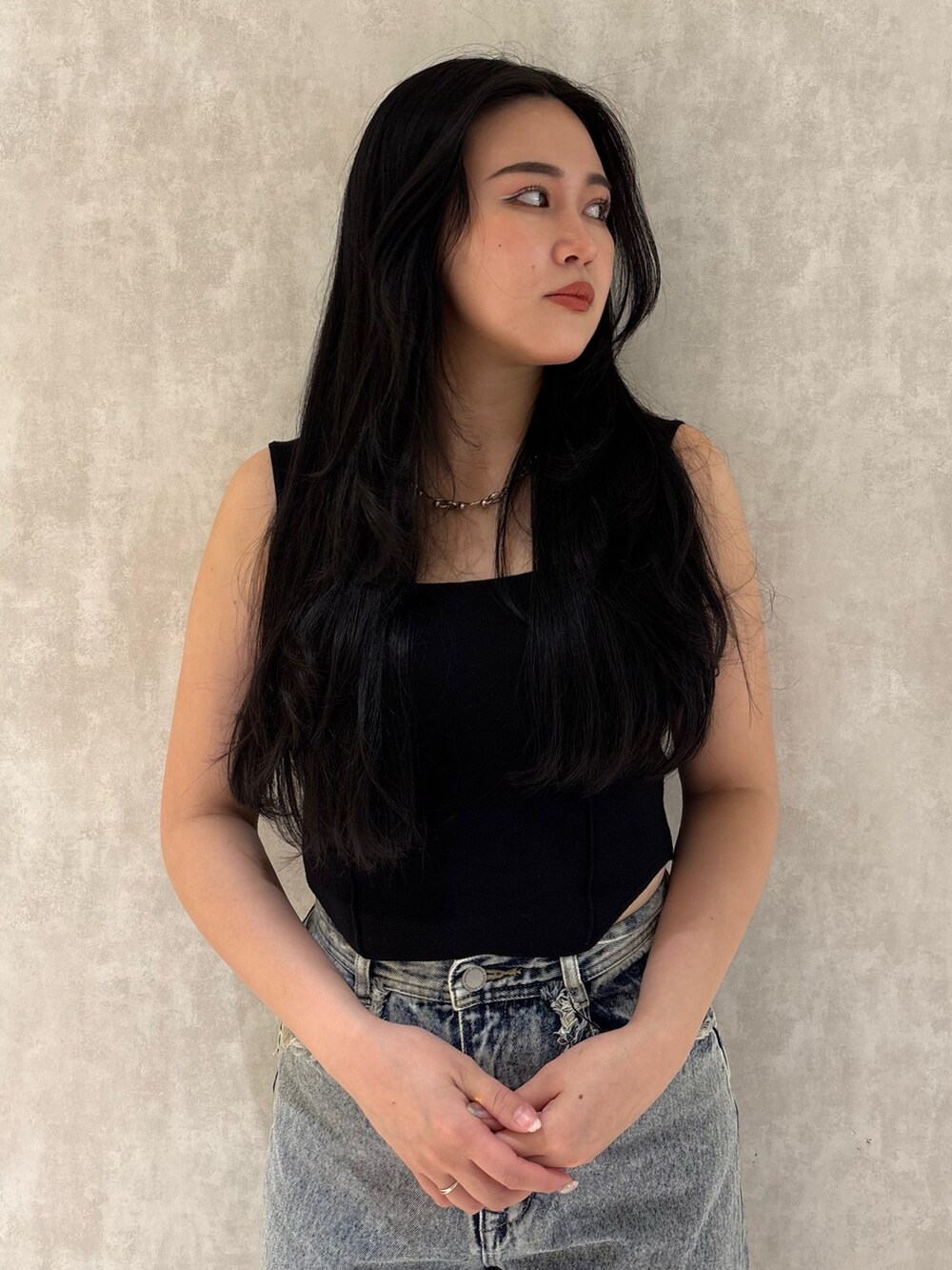 ブラック系のスニーカー、ブルー系のデニムパンツ、ブラック系のニット/セーターを着用したレディースの夏コーディネートの4枚目の写真