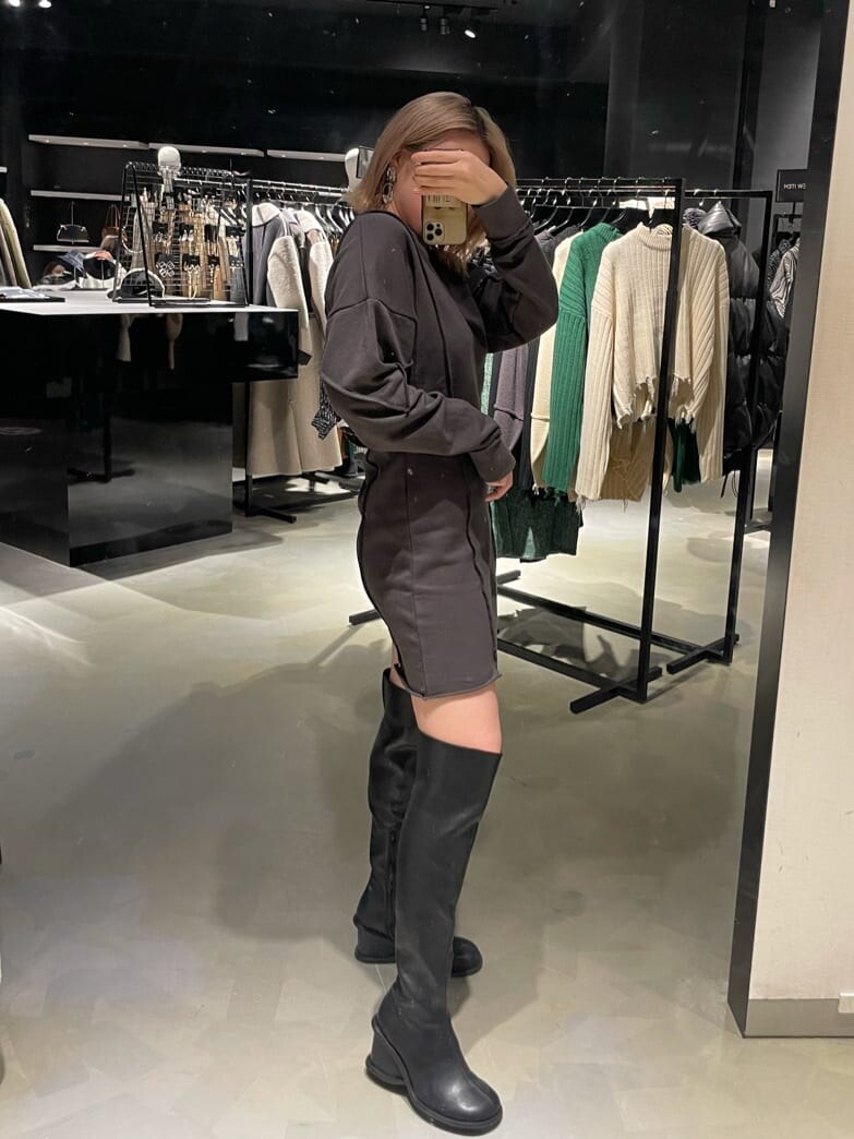 グレー系のワンピース、ブラック系のブーツを着用したレディースの秋コーディネートの2枚目の写真