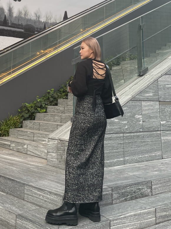 ブラック系のスカート、ブラック系のニット/セーター、ブラック系のキャミソールを着用したレディースの秋コーディネートの2枚目の写真