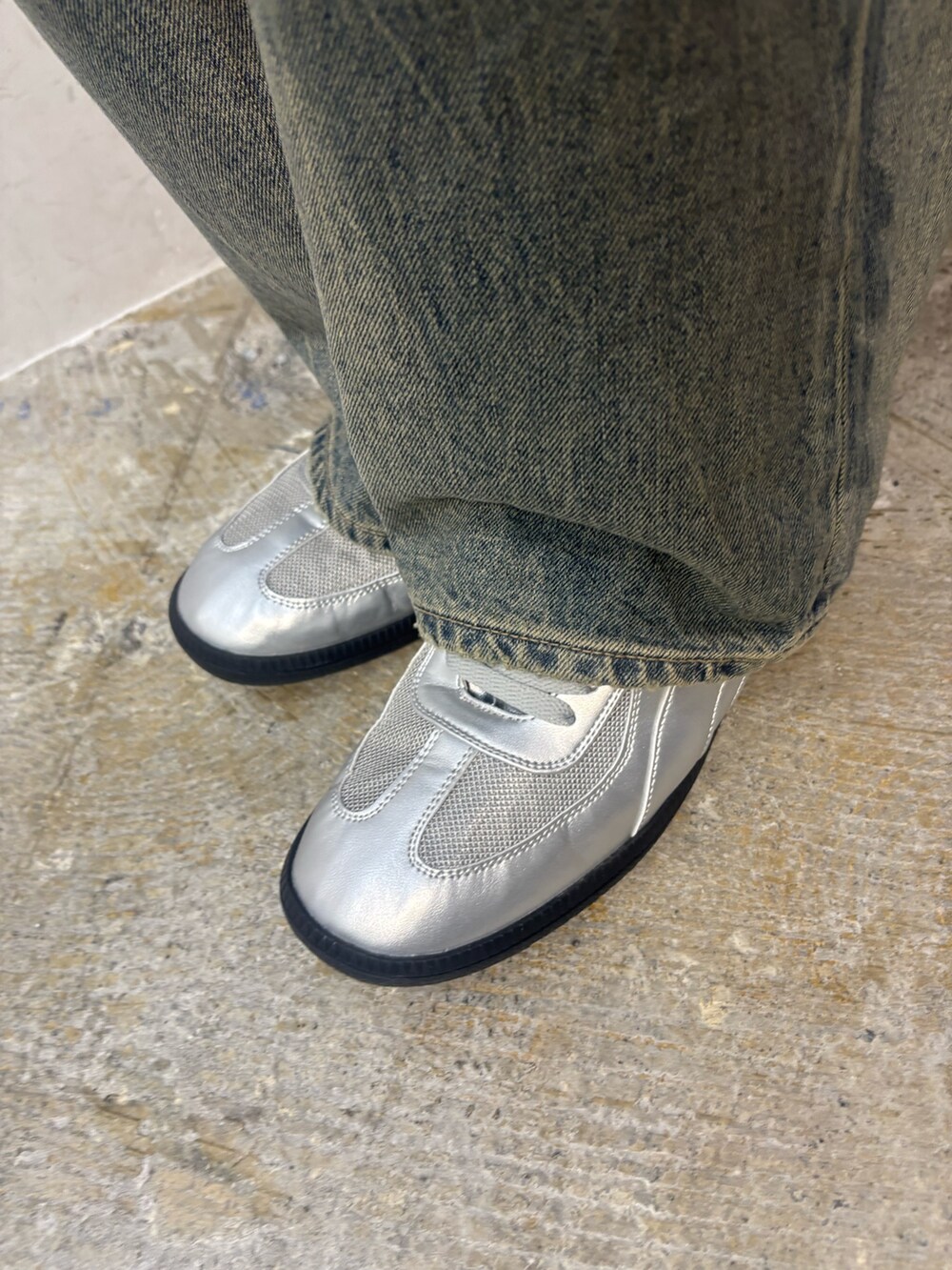 シルバー系のスニーカー、ブルー系のデニムパンツ、ブラック系のシャツ/ブラウスを着用したレディースの春コーディネートの6枚目の写真