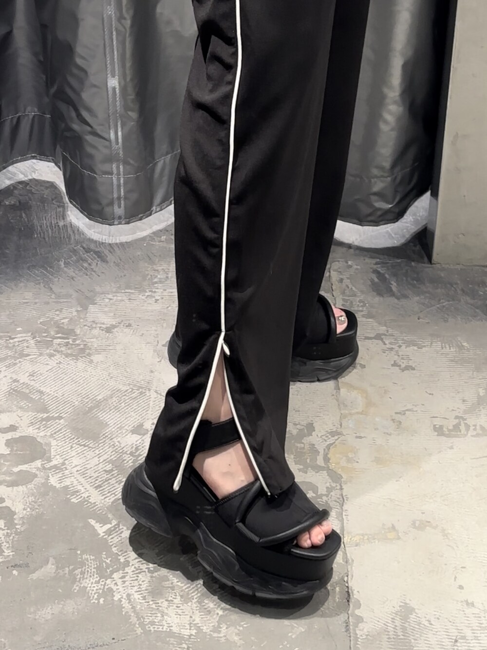 ブラック系のサンダル、ホワイト系のTシャツ/カットソー、ブラック系のスラックスを着用したレディースの夏コーディネートの6枚目の写真