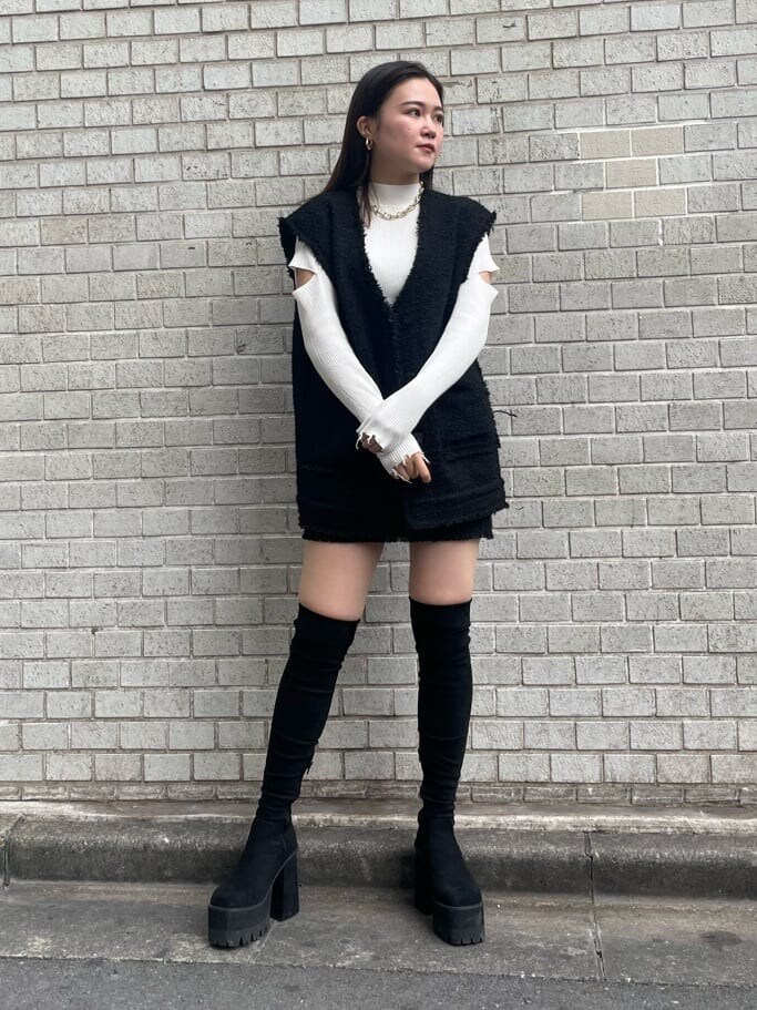 ブラック系のベスト、ブラック系のスカート、ホワイト系のニット/セーターを着用したレディースの秋コーディネートの2枚目の写真