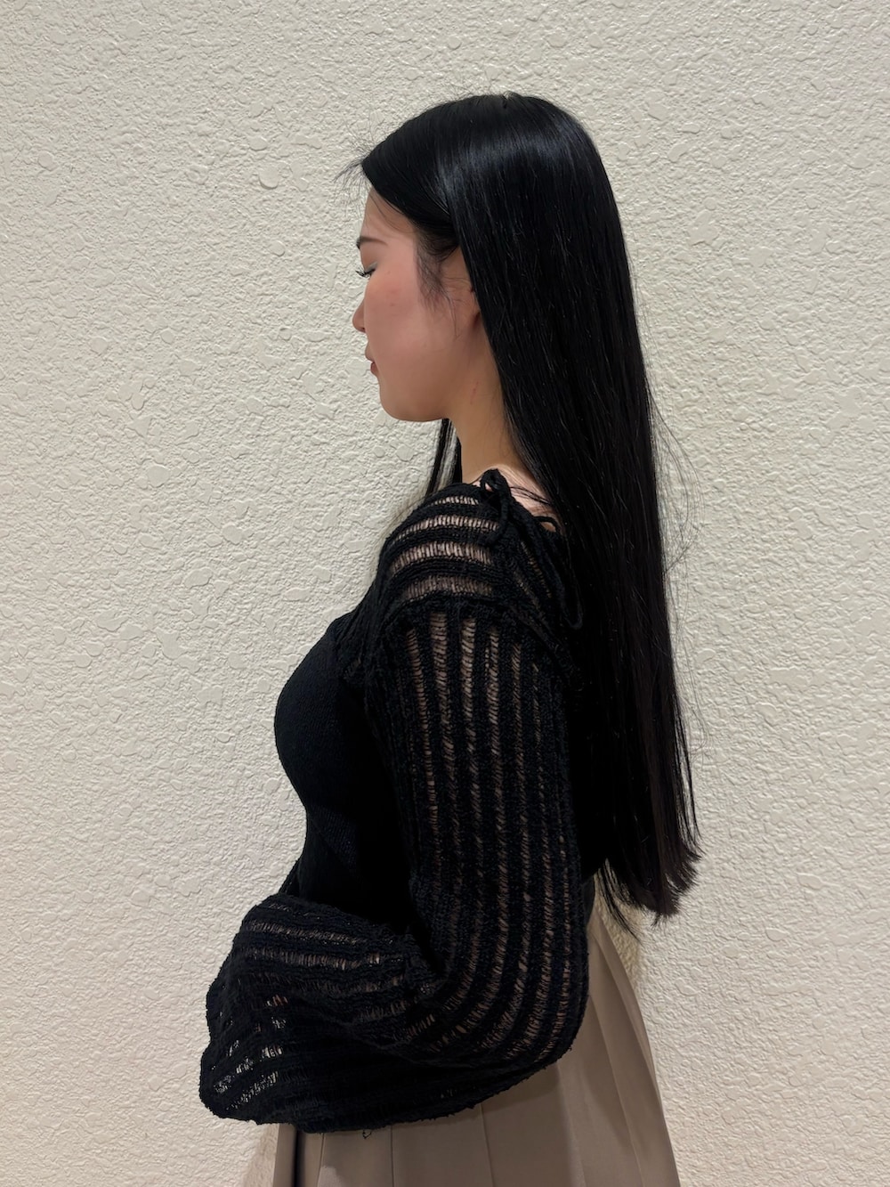 ブラック系のサンダル、ベージュ系のスカート、ブラック系のニット/セーターを着用したレディースの春コーディネートの5枚目の写真