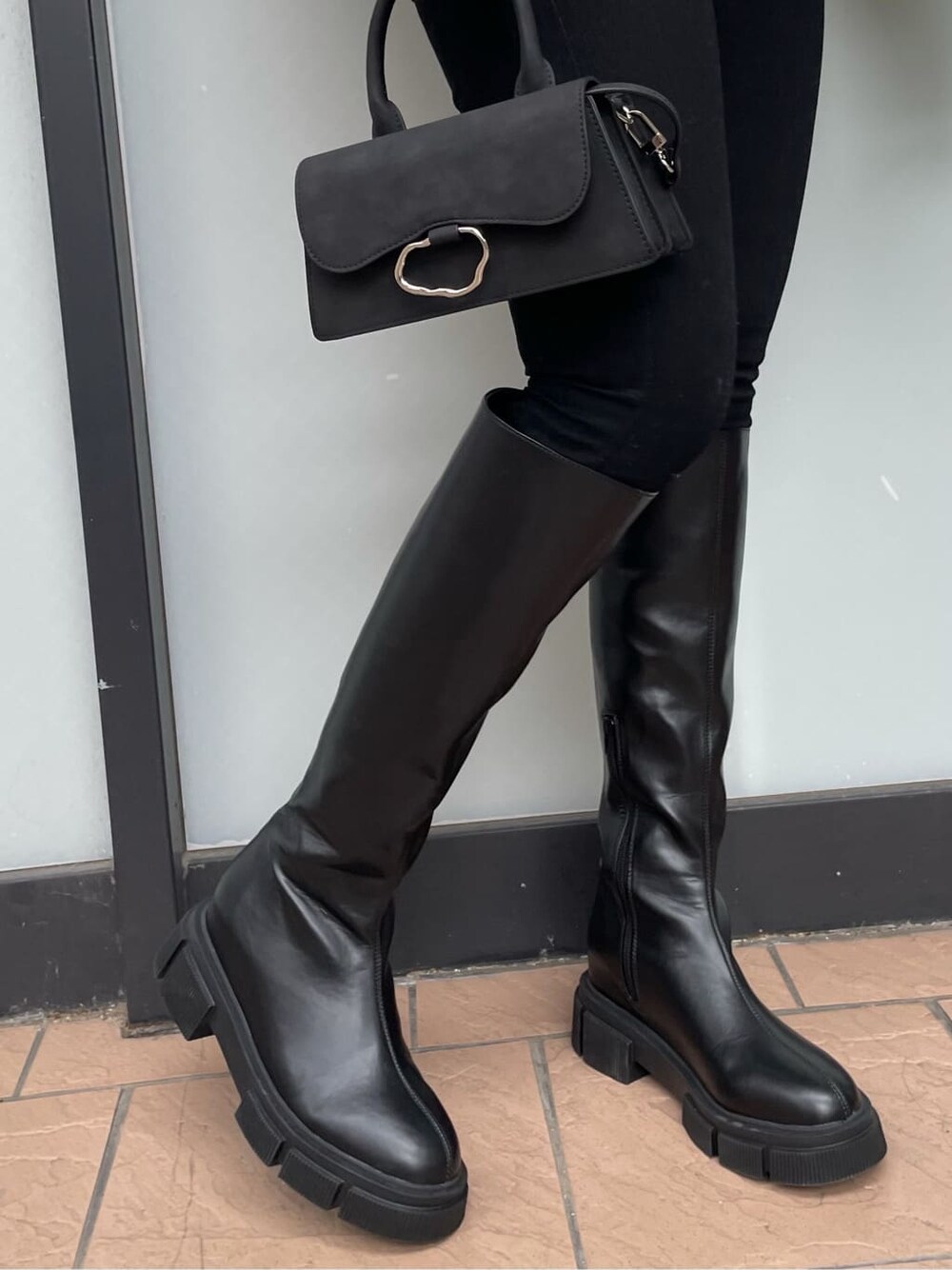 ブラック系のブーツ、ホワイト系のダウンジャケット/コート、ブラック系のデニムパンツを着用したレディースの冬コーディネートの5枚目の写真