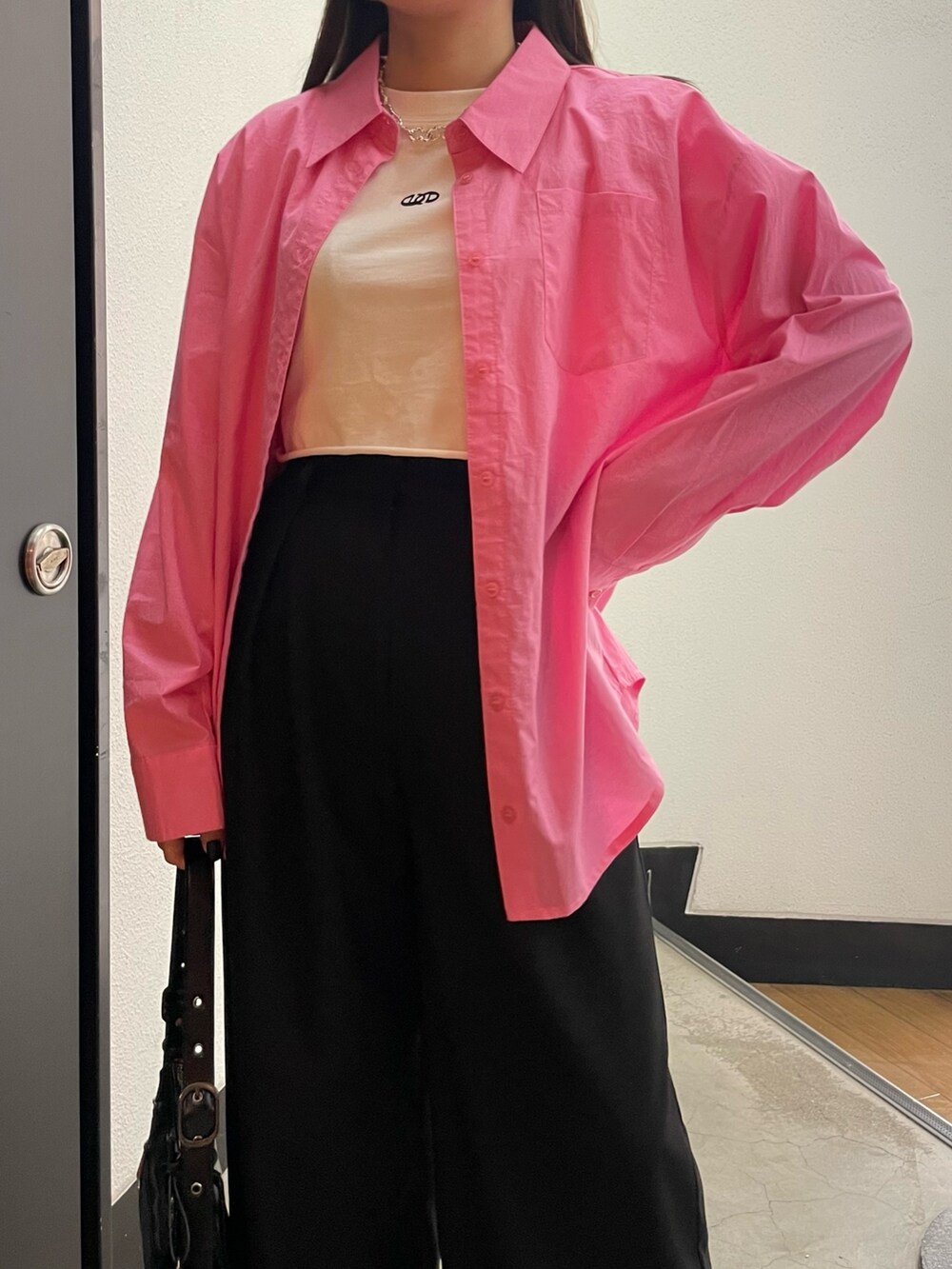 ブラック系のパンプス、ブラック系のハンドバッグ、ピンク系のシャツ/ブラウスを着用したレディースの冬コーディネートの4枚目の写真