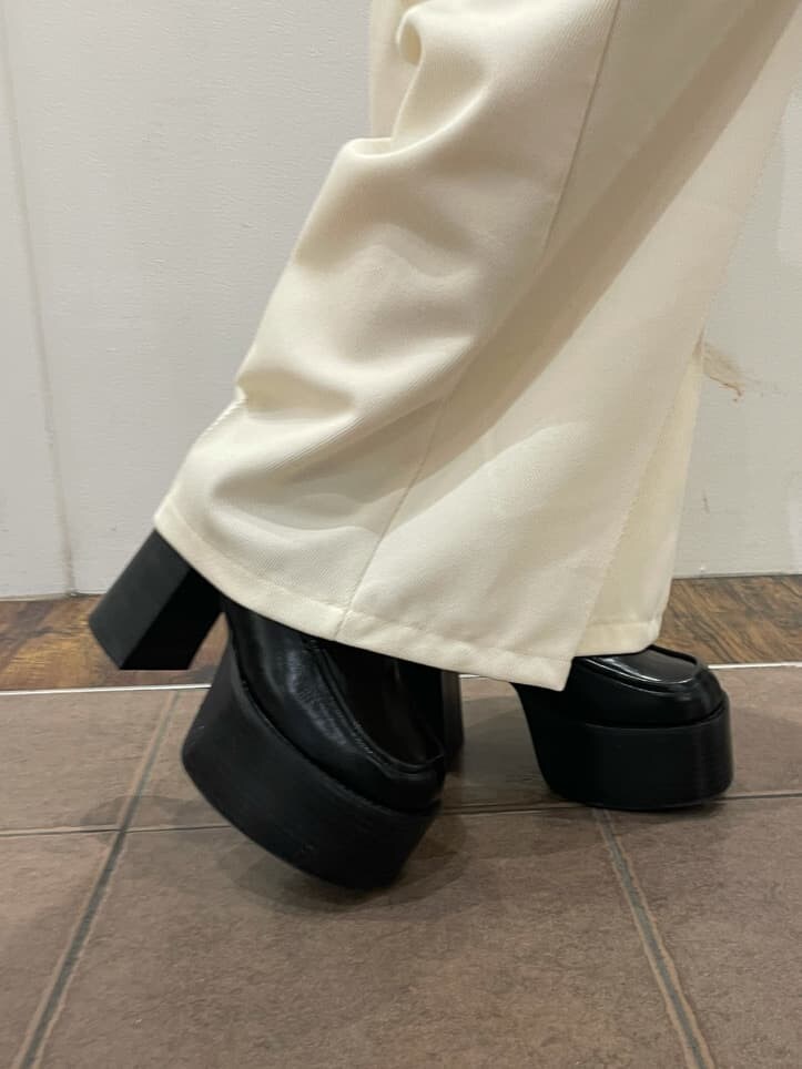 ブラック系のローファー、ホワイト系のその他パンツ、ベージュ系のカーディガン/ボレロを着用したレディースの冬コーディネートの7枚目の写真