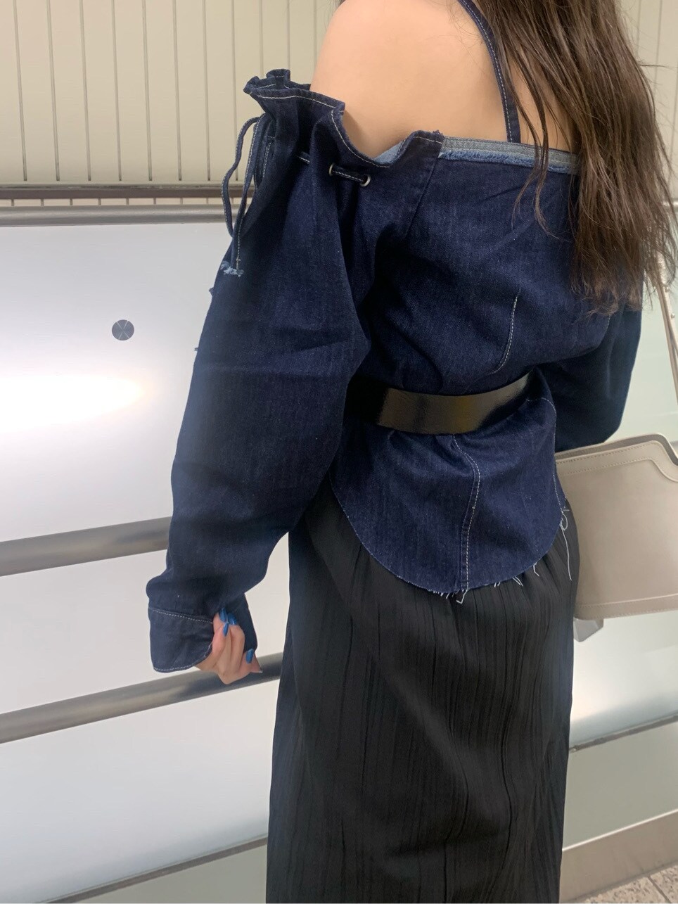 ブラック系のスカート、ホワイト系のショルダーバッグ、ホワイト系のサンダルを着用したレディースの春コーディネートの3枚目の写真