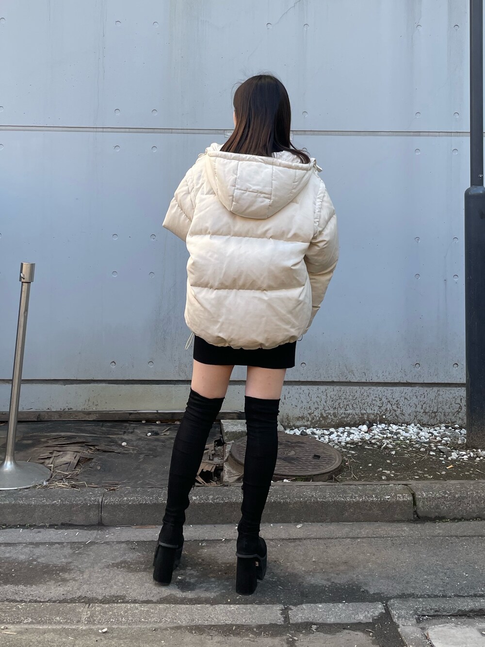 ホワイト系のダウンジャケット/コート、ブラック系のワンピース、ブラック系のブーツを着用したレディースの冬コーディネートの2枚目の写真