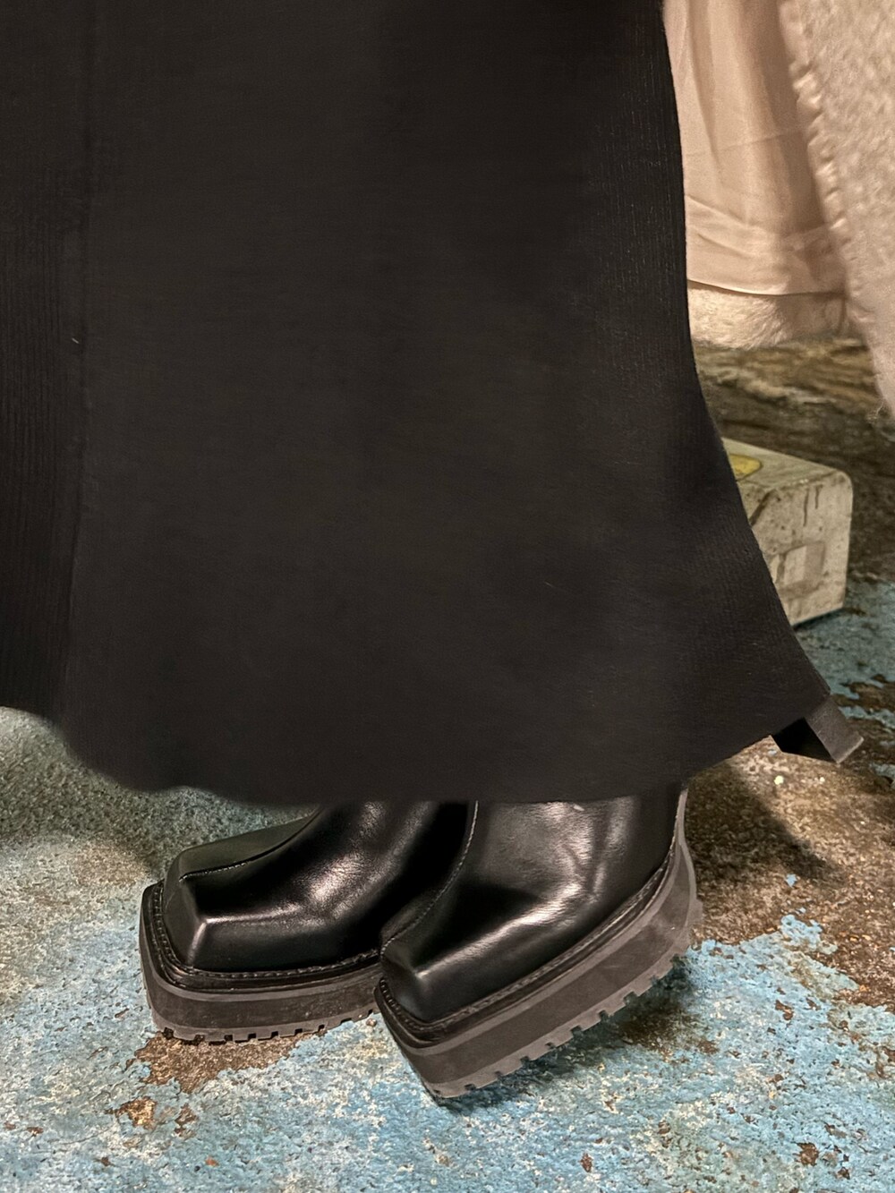 ブラック系のハンドバッグ、ブラック系のワンピース、ブラック系のブーツを着用したレディースの冬コーディネートの5枚目の写真