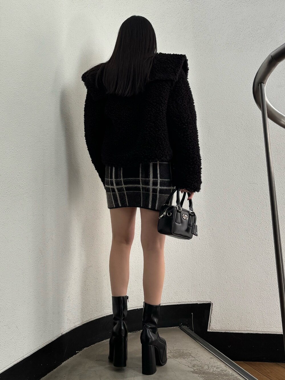 ブラック系のブルゾン、ブラック系のニット/セーター、ブラック系のスカートを着用したレディースの冬コーディネートの3枚目の写真