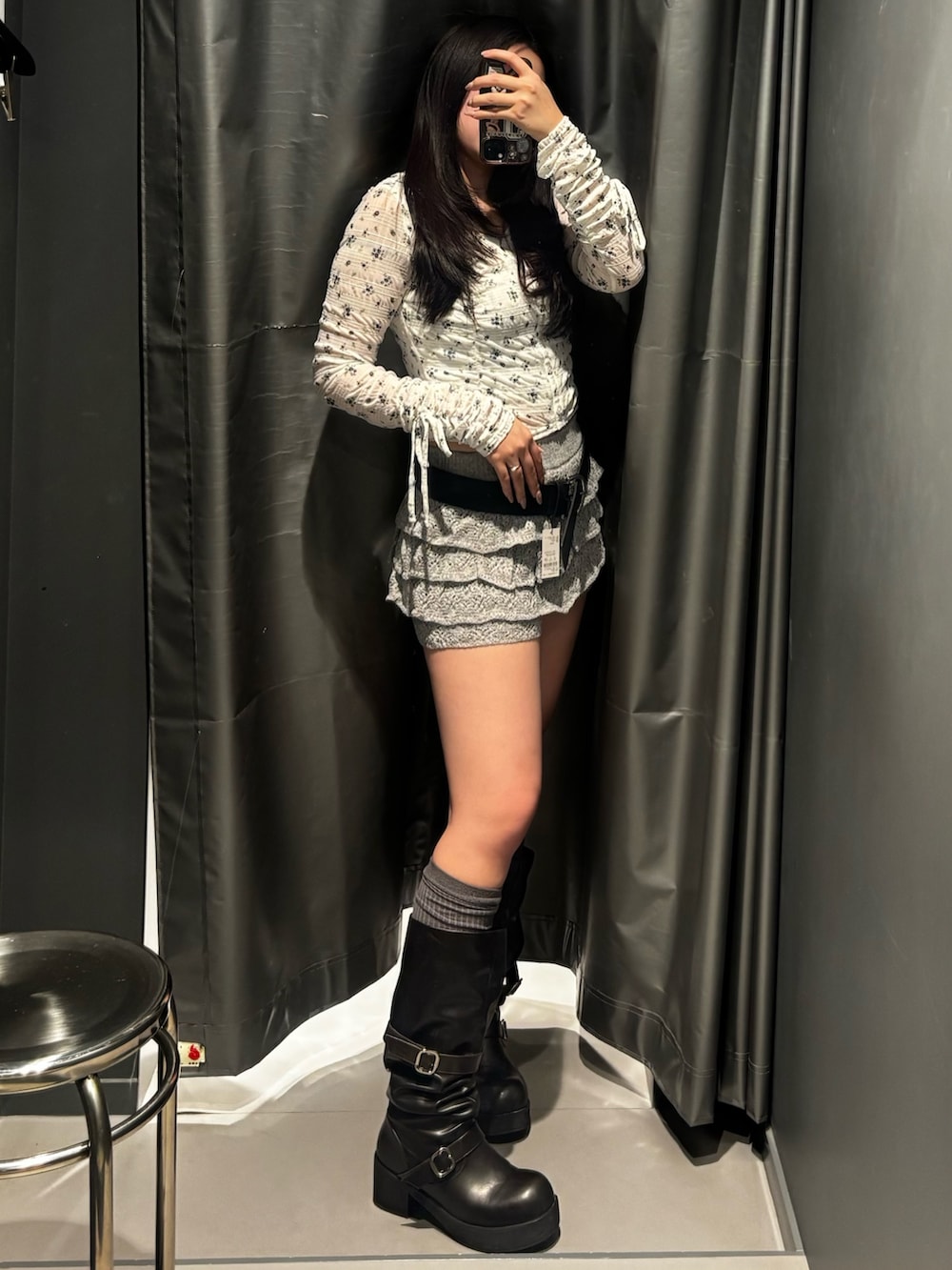 ブラック系のブーツ、グレー系のスカート、ブラック系のTシャツ/カットソーを着用したレディースの冬コーディネートの2枚目の写真